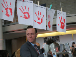 Lars Möller, Mitarbeiter der Kinderkommission, beim Aufhängen der Handabdrücke