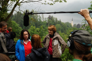 Fernsehkameras, PolitikerInnen, viele Wolken und der Kirchturm der Ortschaft Schliersee.